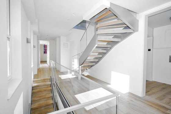 Finished floating stair with wood treads and a glass guard