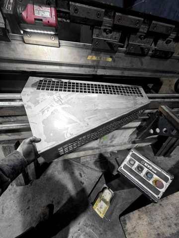 A perforated steel pan at the press brake