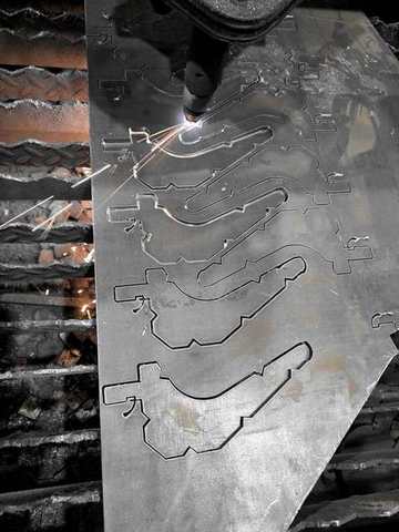 CNC plasma cutting stair stringer plates, sparks flying