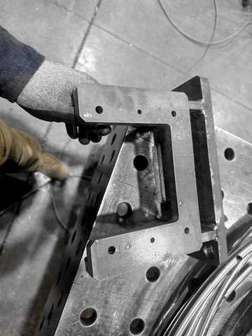 A cut bracket in a gloved hand